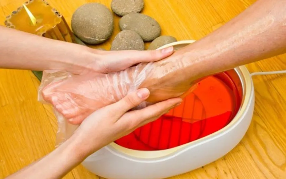 A hand treatment beside a warm wax bath