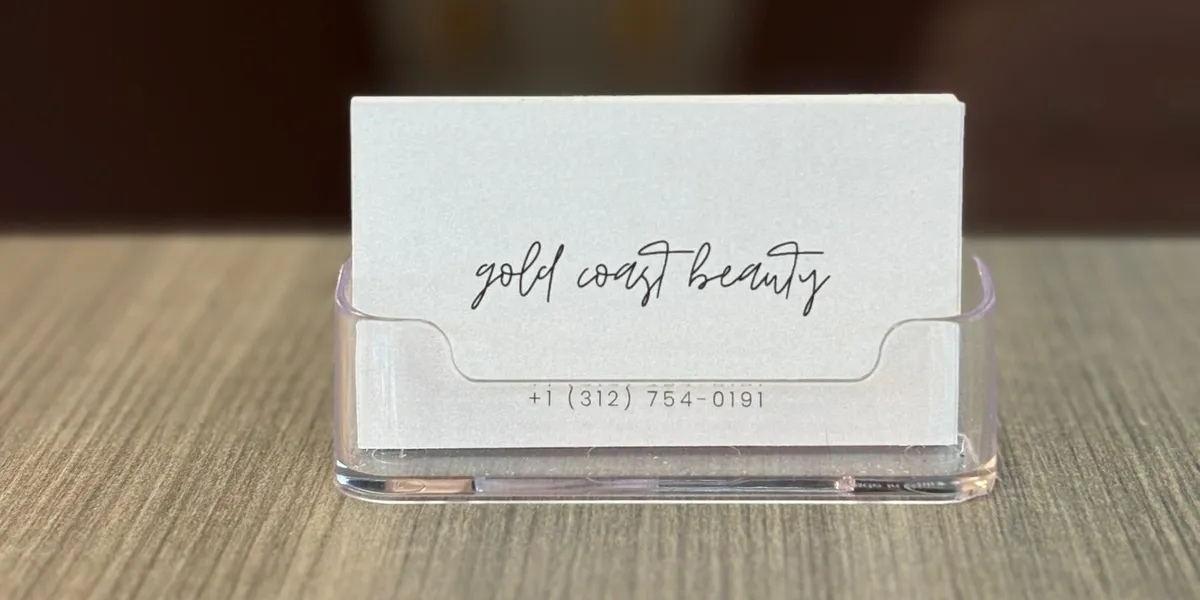 Gold Coast Beauty Spa business cards on a wooden counter